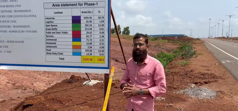 Sadat HM beside the NICDIT Zaheerabad Industrial Smart City Phase-I area statement board, with a new internal road and street lighting behind